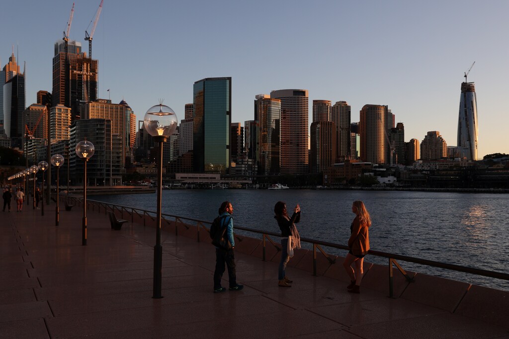 A woman poses for a picture near the Sydney Opera House following the easing of restrictions implemented to curb the spread of the coronavirus disease (COVID-19) in Sydney, Australia, June 23, 2020. REUTERS/Loren Elliott - RC2WEH9QO0TB