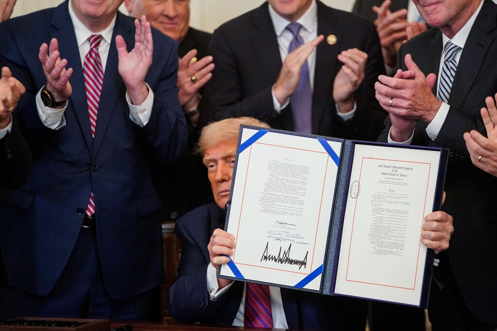 US President Donald Trump holds the signed "Genius Act", which will develop regulatory framework for stablecoin cryptocurrencies and expand oversight of the industry, at the White House in Washington, D.C., U.S., July 18, 2025. REUTERS/Nathan Howard