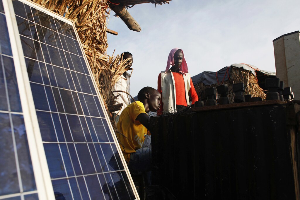 A youth displaced by the fighting charges batteries with solar panels at a makeshift shop in a camp for internally displaced persons (IDPs) at the United Nations (UN) base in Bentiu, Unity State, June 17, 2014. Around 39,000 people have found shelter in the UN base in Bentiu. About 1.5 million people have been displaced, including 378,000 who fled to neighbouring countries, according to the UN Office for the Coordination of Humanitarian Affairs (OCHA). REUTERS/Andreea Campeanu (SOUTH SUDAN - Tags: CIVIL UNREST POLITICS SOCIETY) - RTR3UBTI
