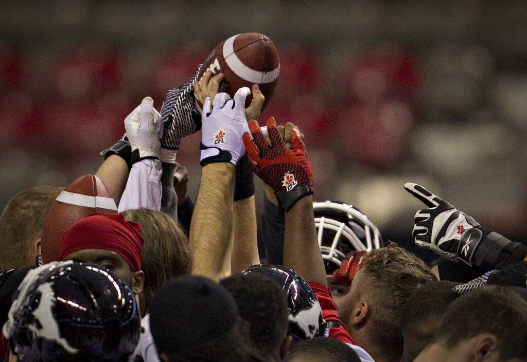 embers of the Calgary Stampeders reach for a ball following a team practice while preparing for the Canadian Football League's 102nd Grey Cup Championship in Vancouver, British Columbia.