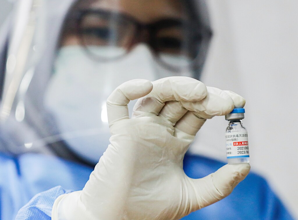 A healthcare worker shows a dose of Sinopharm vaccine against the coronavirus disease (COVID-19) during a mass vaccination program for foreigners in Jakarta, Indonesia, August 24, 2021. REUTERS/Ajeng Dinar Ulfiana - RC2FBP9TXO81