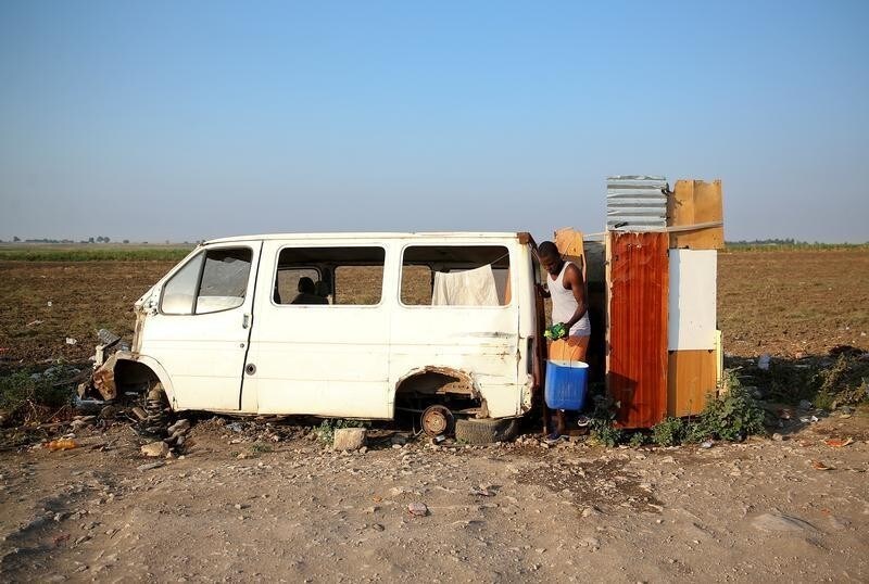 An African migrant labourer gets out of the shower box outside the camp known as the "Great Ghetto", near Foggia, Italy August 8, 2018. Picture taken August 8, 2018.