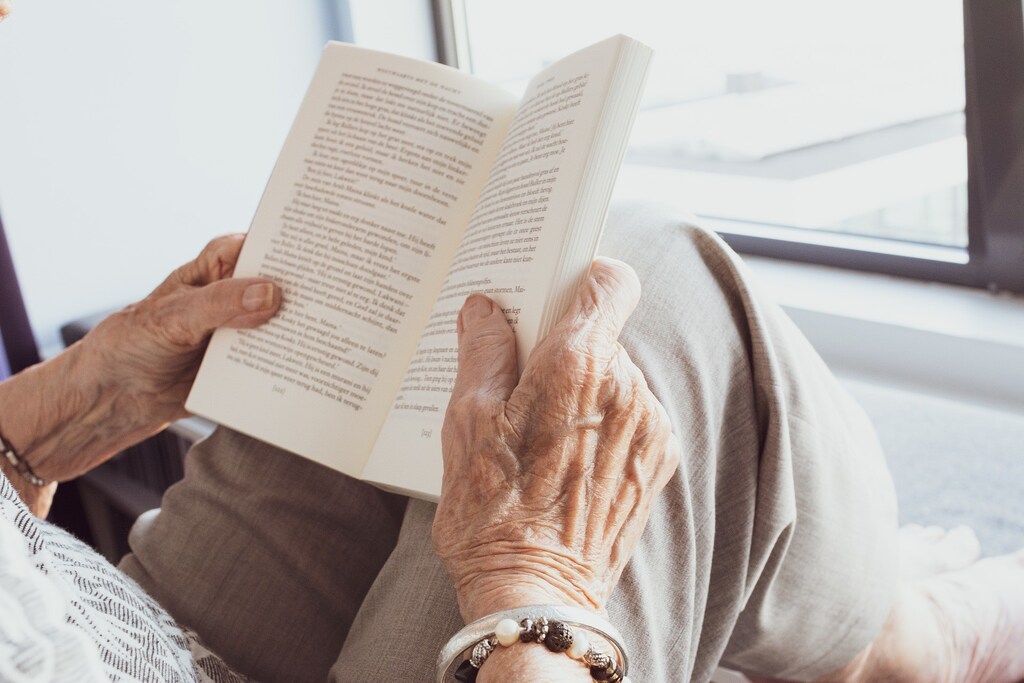 staying mentally engaged, like this older person here who is reading a book, is one of the Okinawan tips for a long life