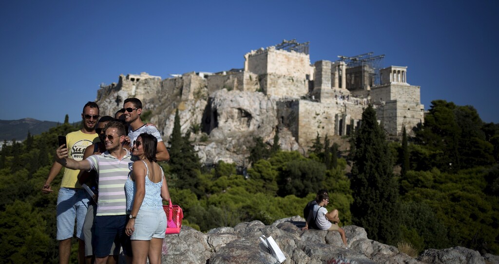 Tourists take a 'selfie' as they visit the hill of Areios Pagos with the archaeological site of the Acropolis in the background in Athens, Greece, August 17, 2015.