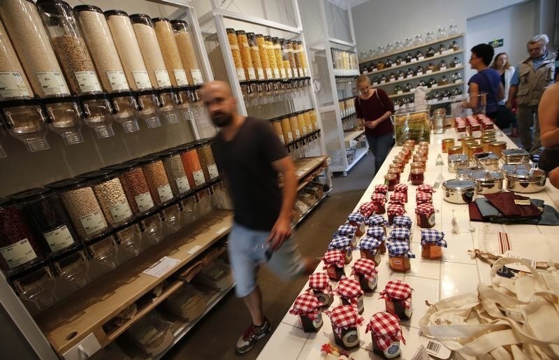 Customers walk inside the Original Unverpackt (Original Unpacked) zero-waste grocery store in Berlin's Kreuzberg district September 16, 2014. Original Unverpackt doesn't sell foodstuffs packaged in disposable boxes, bags, jars or other containers instead shoppers can buy the likes of muesli, rice and pasta by directly helping themselves from the large store containers, filling their own boxes before getting them weighed at the till. For beer and red wine, 'bring-your-own' bottles are just as fine, even vodka is stored in a big demijohn from which customers can buy a few shots, or more. The shop also sells washing up liquid and toiletries in bulk, with toothpaste sold in tablet form. The environmentally-friendly project, which was financed by crowd funding, also allows customers to buy far smaller quantities to avoid waste and to invest in the store's recyclable goods.