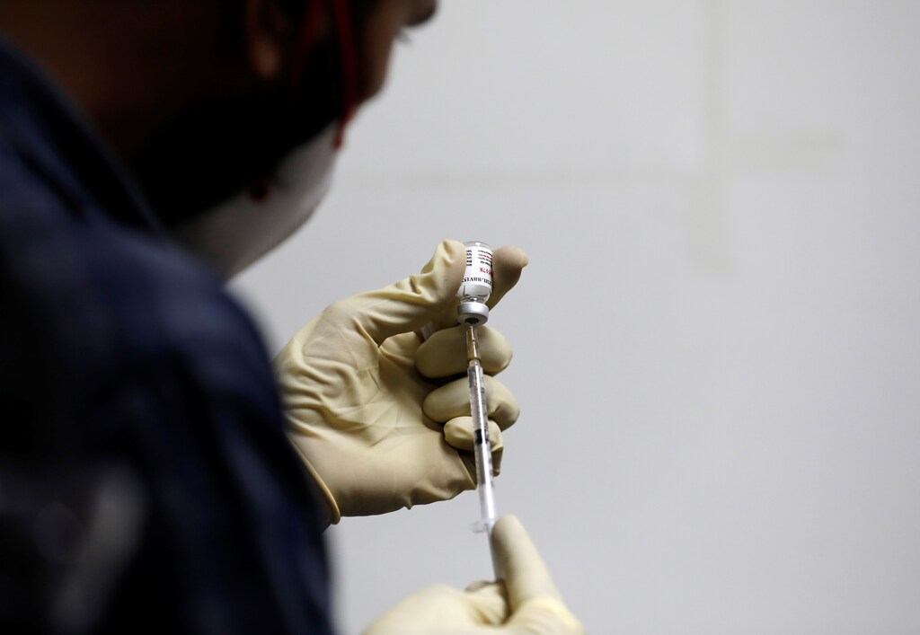 A medic fills a syringe with COVAXIN, an Indian government-backed experimental COVID-19 vaccine, before administering it to a health worker during its trials, at the Gujarat Medical Education and Research Society in Ahmedabad, India, November 26, 2020. REUTERS/Amit Dave - RC2YAK9TYO76