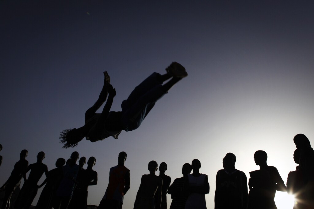 People watch as an acrobat practices flips at Yoff beach in Senegal's capital Dakar, Novermber 1, 2009