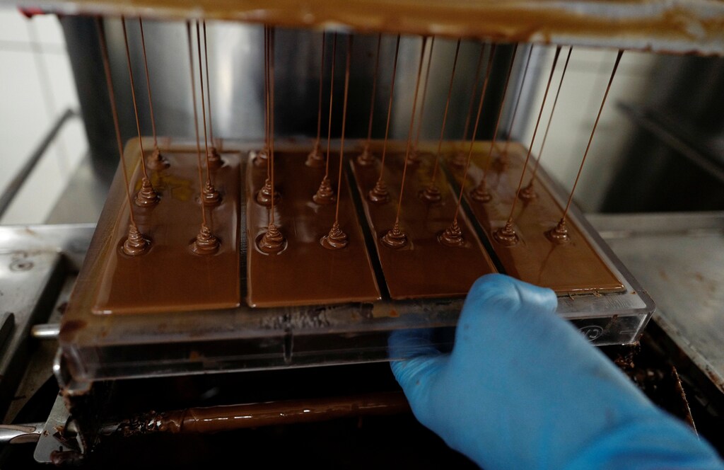 A man fills chocolate into a bar chocolate mould at the Lotte Wedel factory in Warsaw, Poland April 18, 2018. REUTERS/Kacper Pempel - RC12E0B30FF0