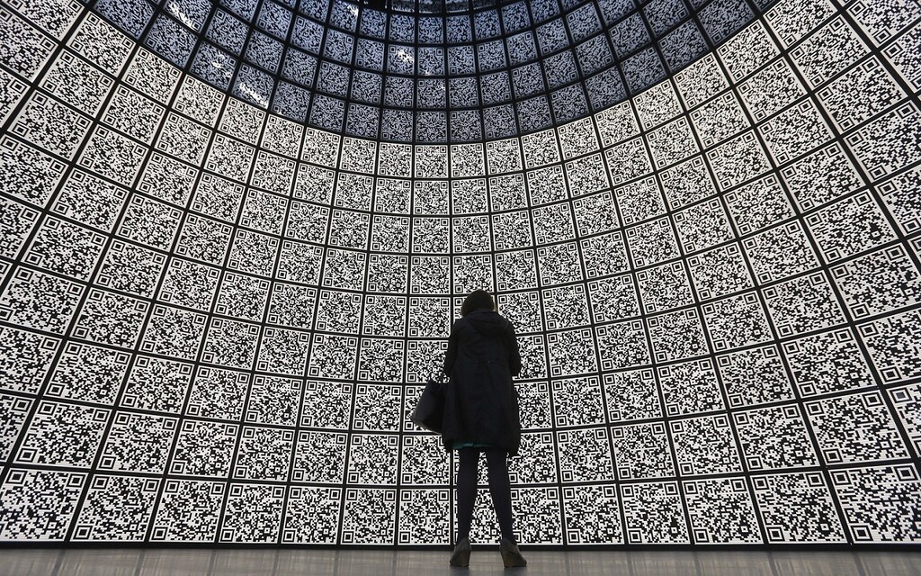 A visitor stands in front of QR-codes information panels during a ceremony to open an information showroom dedicated to the Zaryadye park project in central Moscow April 29, 2014. The showroom, shaped as a dome which houses exhibition halls covered with QR-codes information panels and displaying digital illustration of the project, was opened by Moscow's Mayor Sergei Sobyanin on Tuesday on the site of the future park in a few minutes walk distance from Red Square and the Kremlin, according to organizers. REUTERS/Maxim Shemetov