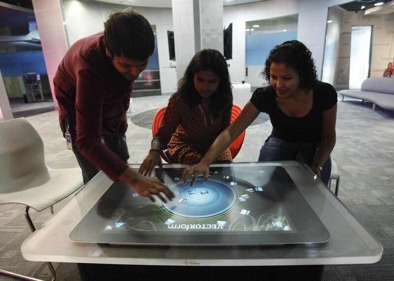 Employees demonstrate the use of the newly-designed prototype of a touch-sensitive table at Microsoft India's Development Center in the Gachibowli IT district in Hyderabad, in the southern state of Andhra Pradesh March 6, 2012. Picture taken on March 6, 2012. REUTERS/Vivek Prakash (INDIA - Tags: BUSINESS SOCIETY EMPLOYMENT SCIENCE TECHNOLOGY) - GM1E8450XD101