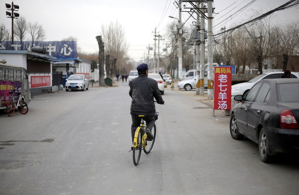 A man rides an Ofo bike-sharing bicycle in a village on the outskirts of Beijing, China December 22, 2018. REUTERS/Jason Lee - RC196E4D0600