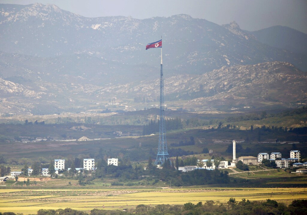A North Korean flag is seen on top of a tower near the truce village of Panmunjom in the demilitarised zone (DMZ) separating North Korea from South Korea, about 55 km (34 miles) north of Seoul, September 25, 2013. Panmunjom is located in one of the world's most heavily fortified frontiers, DMZ, the 4-km (2.5 mile) wide buffer that runs along the heavily armed military border. The divided Korean peninsula is still technically at war, with the 1950-53 Korean War ending in an armistice rather than a peace treaty. REUTERS/Lee Jae-Won (NORTH KOREA - Tags: MILITARY POLITICS) - RTX13YMG