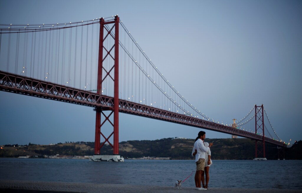 A couple takes a picture near the 25 April Bridge in Lisbon, Portugal August 22, 2016. Picture taken August 22, 2016. REUTERS/Rafael Marchante - D1BETYKLINAB