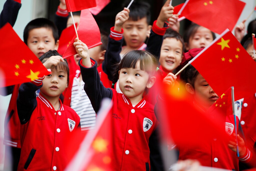 Children wave Chinese national flags as they take part in a celebration marking the upcoming National Day, at a kindergarten in Hangzhou, Zhejiang province, China September 29, 2017. REUTERS/Stringer ATTENTION EDITORS - THIS IMAGE WAS PROVIDED BY A THIRD PARTY. CHINA OUT. - RC1CFDF5CE30