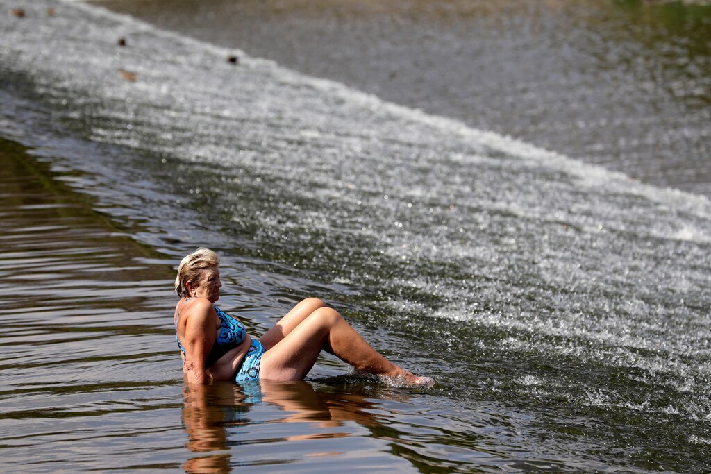 A woman cools off in the Berounka river during a heatwave in the village of Dobrichovice, near Prague, Czech Republic, August 12, 2020. REUTERS/David W Cerny - RC2GCI9V5HJL