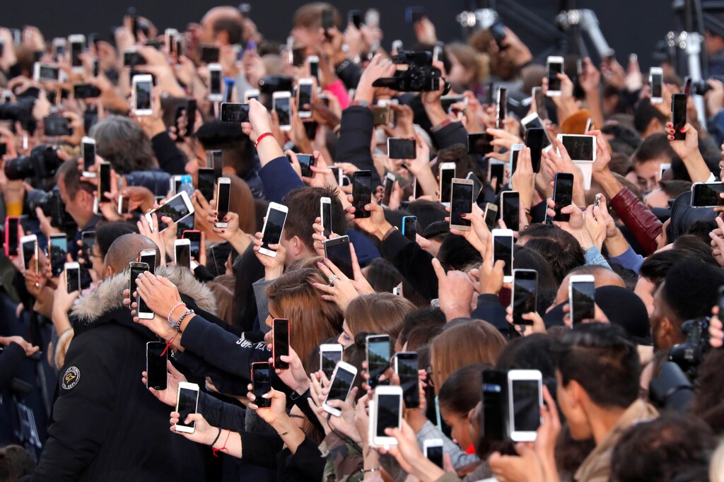 People use their smartphone to take photos of the L'Oreal fashion show on the Champs Elysees avenue during a public event organized by French cosmetics group L'Oreal as part of Paris Fashion Week, France, October 1, 2017. REUTERS/Charles Platiau TPX IMAGES OF THE DAY - RC1CAB6813E0
