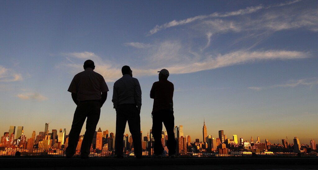 People watch the sun set over New York from a park in Weehawken, New Jersey September 8, 2013.