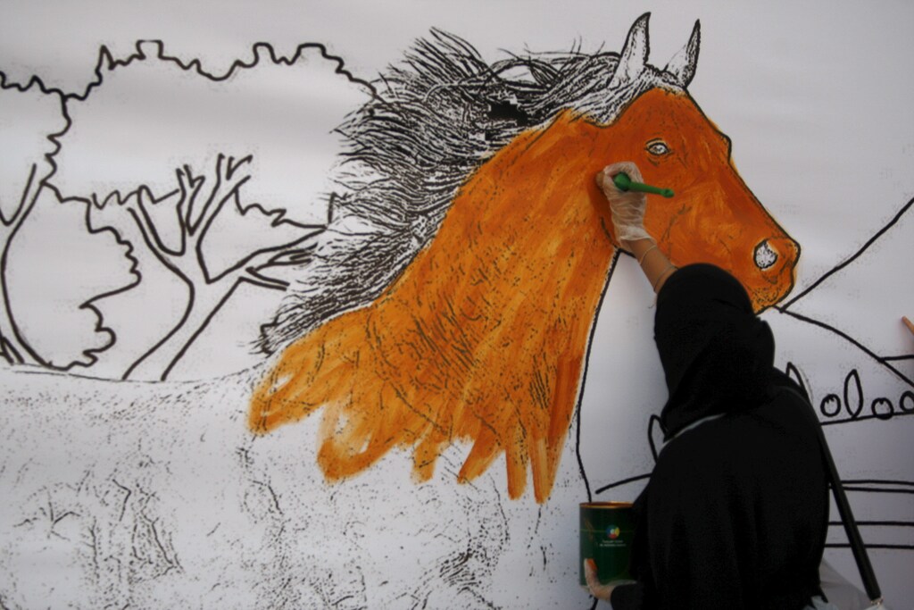 A Saudi woman paints a mural during an activity for national drawings in Jeddah October 29, 2015. October REUTERS/Mohamed Al Hwaity - RTX1TUMU