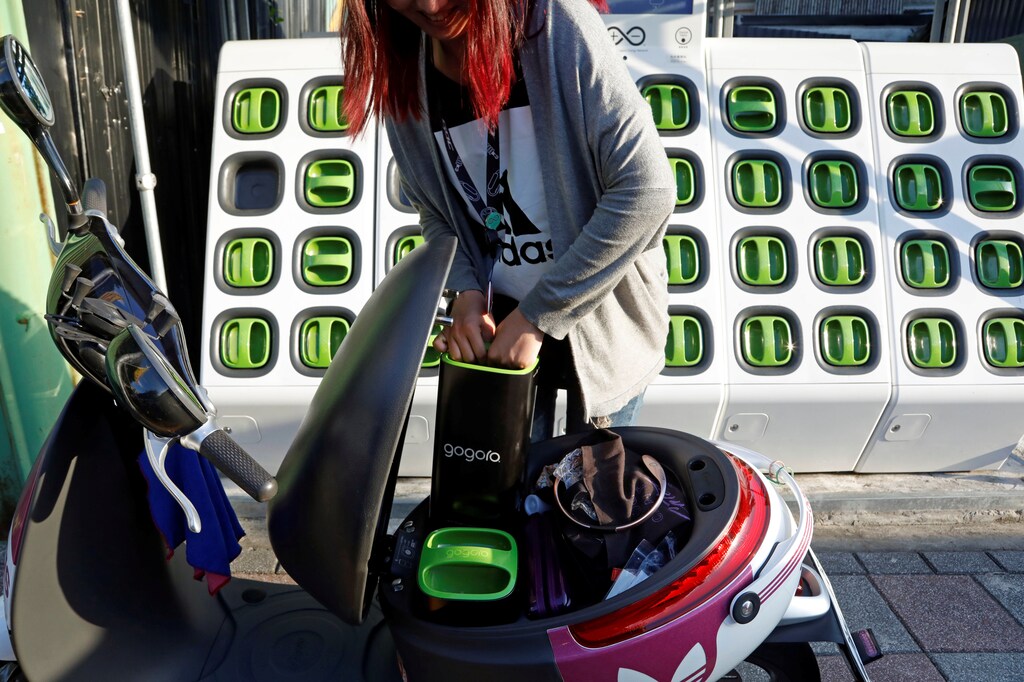 A woman charges battery of her electric scooter at the Gogoro's charging station in Taipei, Taiwan August 10, 2017. REUTERS/Tyrone Siu - RC1E41C2BA90