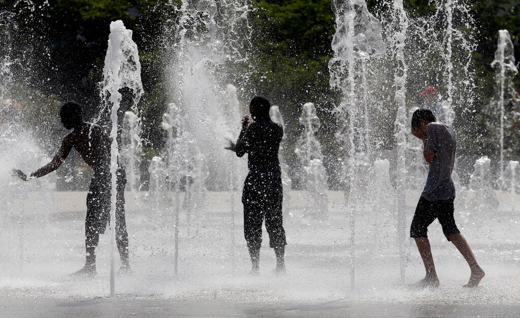 Teenagers cool off in water fountains in a park as hot summer temperatures hit Paris, France, June 22, 2017. REUTERS/Jean-Paul Pelissier - RTS186RP