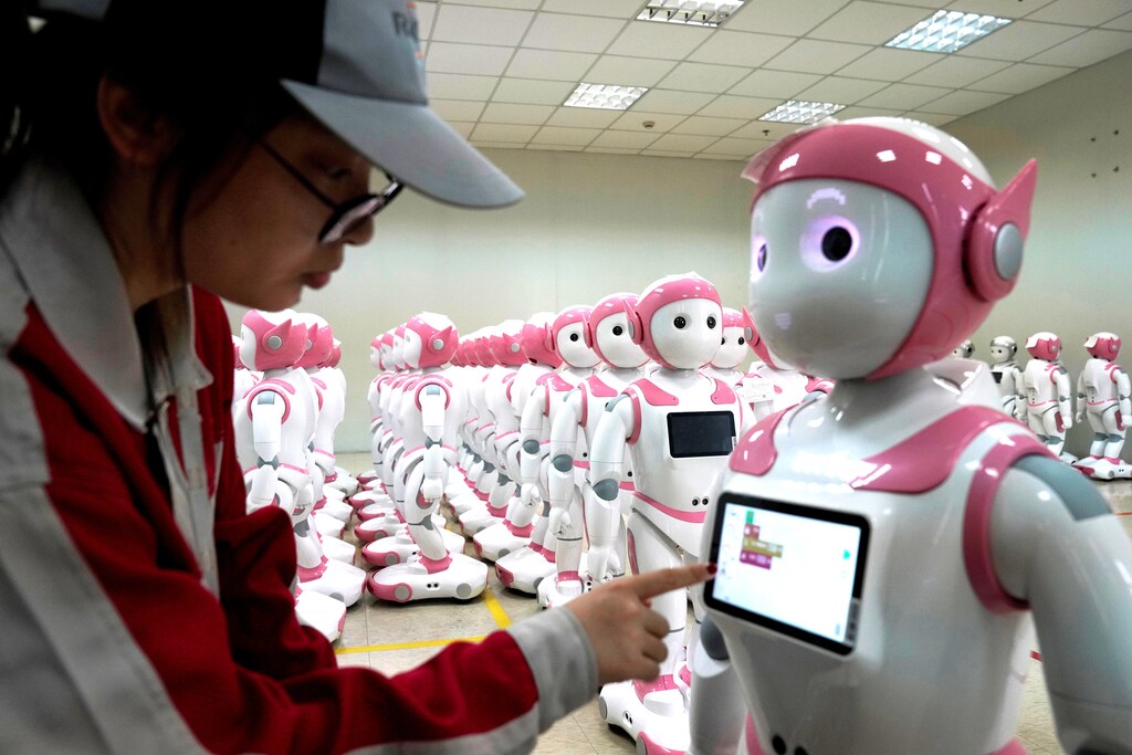 A worker puts finishing touches to an iPal social robot, designed by AvatarMind, at an assembly plant in Suzhou, Jiangsu province