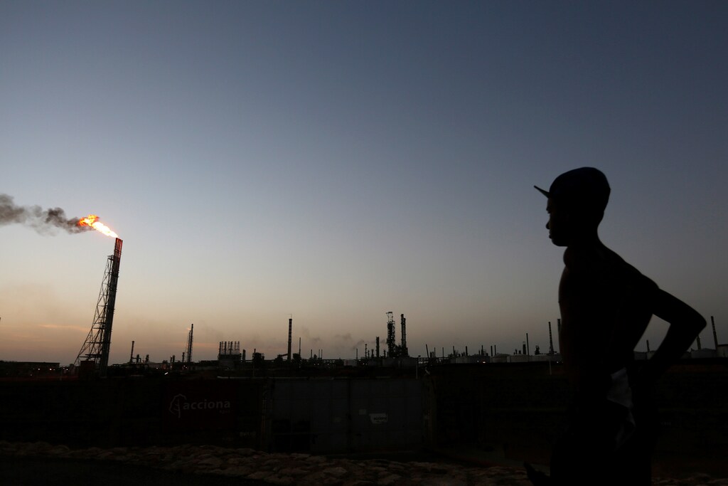 A man stands close to the Cardon refinery which belongs to the Venezuelan state oil company PDVSA in Punto Fijo, Venezuela .