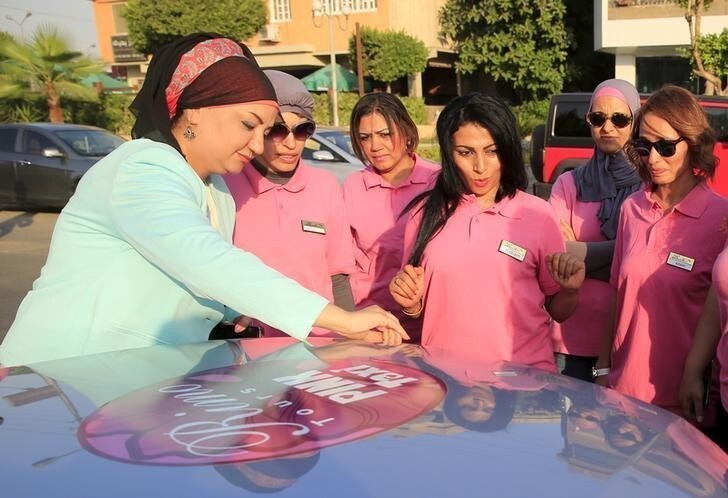 Reem Fawzy (L), the director of the Pink Taxi company, stands with her drivers in a parking lot in Cairo, Egypt, September 6, 2015. Pink uniforms, a pink logo on the cars, and even pink nail polish - it's all part of the look of women-drivers working for Egypt's first women-only taxi service. The Pink Taxi company hires only women drivers and gives rides to only female passengers. The company was started in an effort to provide a safe taxi service for women in a country with high rates of sexual harassment, said Fawzy. Picture taken September 6, 2015. REUTERS/Amr Abdallah Dalsh