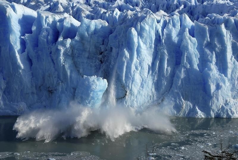 Splinters of ice peel off from one of the sides of the Perito Moreno glacier in a process of a unexpected rupture during the southern hemisphere's winter months, near the city of El Calafate in the Patagonian province of Santa Cruz, southern Argentina, July 7, 2008. The Perito Moreno glacier, part of the Los Glaciares National Park, a World Heritage site, measures 250 square kilometers (97 square miles), and is one of the few glaciers which is advancing instead of retreating. REUTERS/Andres Forza (ARGENTINA) - RTX7QJ5