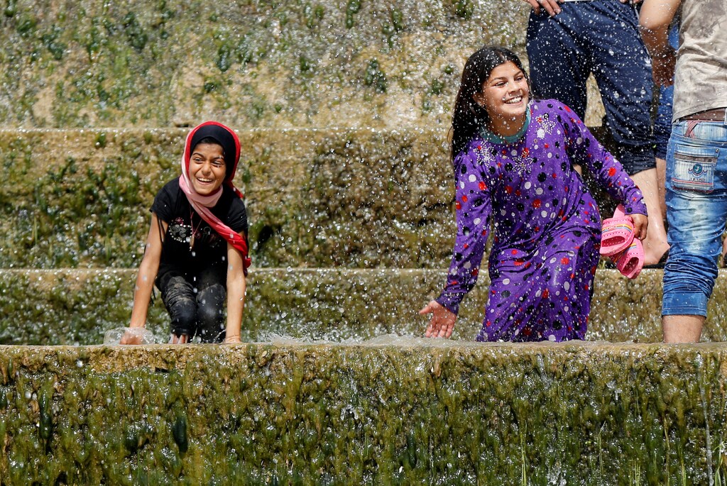 Iraqi girls play with water as they enjoy their Friday holiday with their family at Shallalat district (Arabic for "waterfalls") in eastern Mosul, Iraq, April 21, 2017. REUTERS/ Muhammad Hamed - RTS13CR3