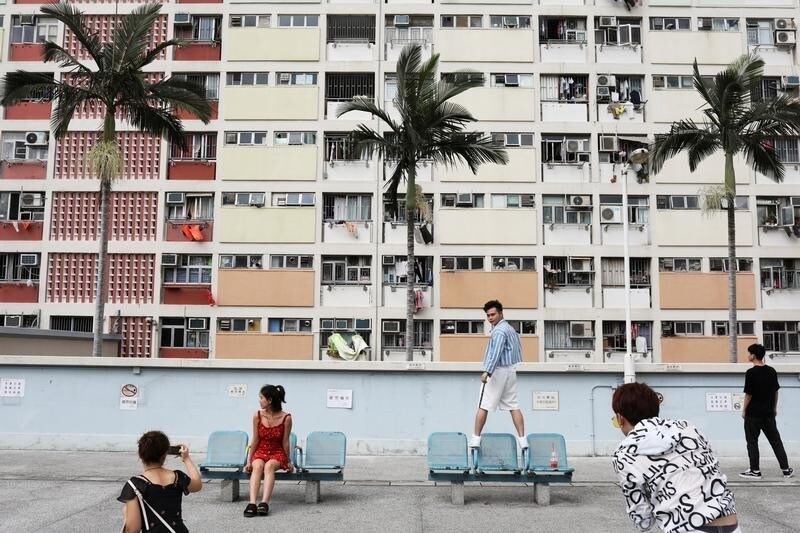 People take photo in front of Choi Hung estate, an apartment complex that became famous because of the rainbow color paints in Hong Kong, China, June 23, 2019. REUTERS/Ann Wang TPX IMAGES OF THE DAY - RC132CB9B710