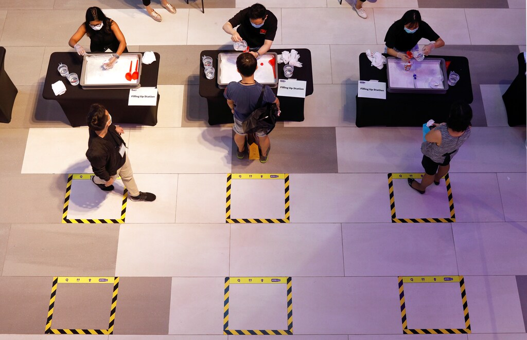 People queue to get a free refill of hand sanitiser at a mall , as the spread of coronavirus disease (COVID-19) continues, in Singapore, April 1, 2020.