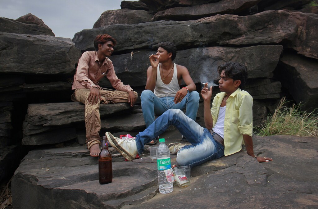 Gopal Kishan (R), 15, smokes a cigarette as he drinks with his friends on the outskirts of their village near Kota, located in the northwestern state of Rajasthan, July 17, 2012. Krishna married her husband Gopal when she was 11 and he was 13. Krishna gave birth to a son four months ago on October 2012, losing a lot of blood during the very difficult delivery and remain in the hospital for several days. The legal age for marriage in India is 18, but marriages like these are common, especially in poor, rural areas where girls in particular, are married off young. Picture taken July 17, 2012.