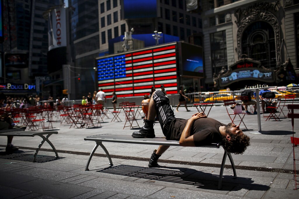 A man takes a nap during a sunny day in Times Square in New York July 19, 2015. REUTERS/Eduardo Munoz - GF10000164260