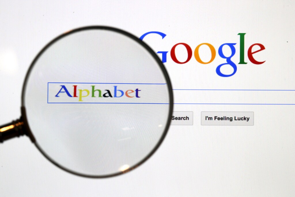 A Google search page is seen through a magnifying glass in this photo illustration taken in Berlin, August 11, 2015. Google Inc is changing its operating structure by setting up a new company called Alphabet Inc, which will include the search business and a number of other units. REUTERS/Pawel Kopczynski - RTX1NWEP