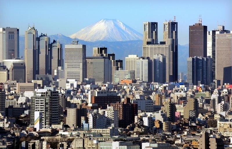 Japan's Mt Fuji, covered with snow, is seen through Shinjuku skyscrapers in Tokyo January 8, 2006. The recovery of Japan's economy has been helped by a strong recovery in exports and a rise in corporate profits that has filtered through to lower unemployment rates and raise incomes. The recovery has bolstered confidence in the stock market, where the Nikkei share average surged 40 percent in 2005.