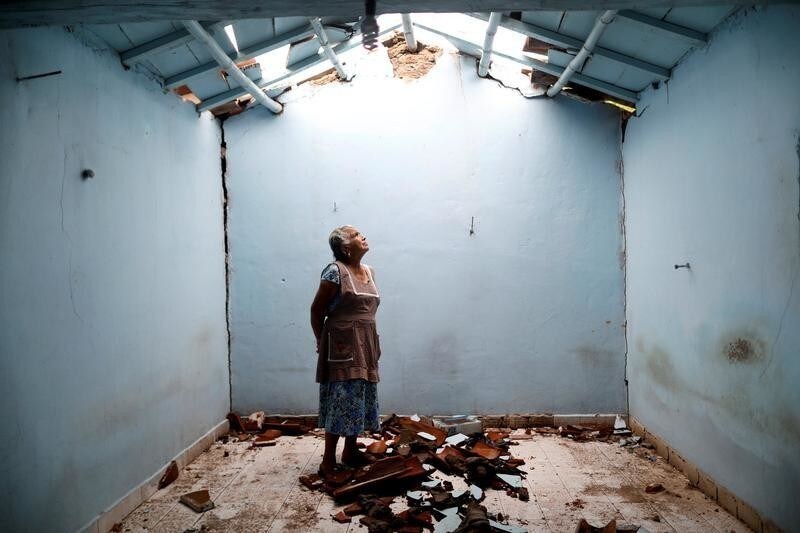 Tomasa Mozo, 69, a housewife, looks up at the roof as she poses for a portrait inside the ruins of her house after an earthquake in San Jose Platanar, at the epicentre zone, Mexico, September 28, 2017. The house was badly damaged but with the help of her family Mozo rescued some furniture. She lives in another room of her house and hopes to repair the damage as soon as possible. "I'm afraid to go out, I can not sleep," Mozo said. REUTERS/Edgard Garrido SEARCH "GARRIDO PORTRAIT" FOR THIS STORY. SEARCH "WIDER IMAGE" FOR ALL STORIES. TPX IMAGES OF THE DAY. - RC1DC662B340