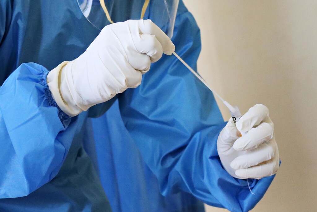 a medical professional holding a COVID-19 test