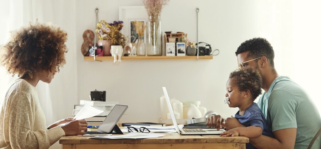 A family using computers and tablets at a table together. Taking a data-driven approach to digital safety is becoming increasingly important as our lives move online.