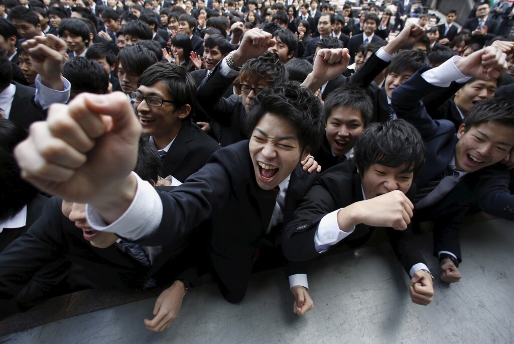 Japanese college students shout and raise their fists during a pep rally held to boost their morale ahead of their job hunt