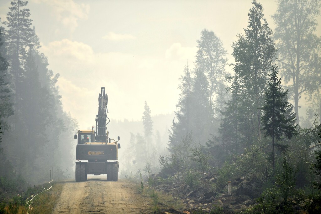 A forest machine that builds a fire pit in the fire-borne area around Farila, Halsingland, in central Sweden, July 25, 2018. TT News Agency/Erik Simander/via REUTERS ATTENTION EDITORS - THIS IMAGE WAS PROVIDED BY A THIRD PARTY. SWEDEN OUT. NO COMMERCIAL OR EDITORIAL SALES IN SWEDEN - RC1D69FD13D0