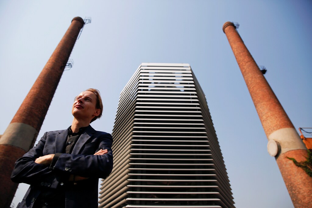 Dutch artist and innovator Daan Roosegaarde poses in front of the Smog Free Tower, the world's largest smog vacuum cleaner as he presents his The Smog Free Project at D-751 art zone in Beijing September 29, 2016. The Smog Free Project consist of 7-meter tall the Smog Free Tower, the large air purifier that creates an area of clean air around it and the Smog Free Jewellery that are made of compressed smog particles. REUTERS/Damir Sagol - RTSPYEC