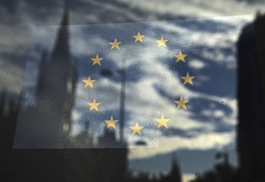 The European Union flag is pictured in a window reflecting a street in London, October 26, 2011. The European Union's leaders are meeting to work out a comprehensive deal to resolve the euro zone debt crisis and find a way to give the region's bailout fund greater firepower. REUTERS/Luke MacGregor (BRITAIN - Tags: BUSINESS POLITICS) - RTR2T84N
