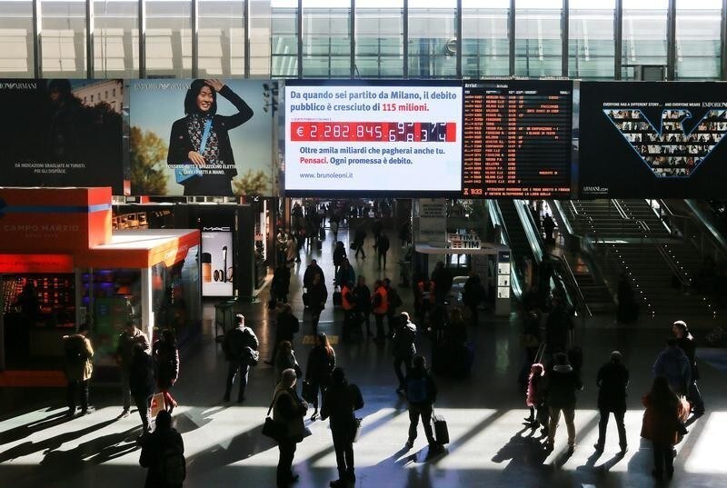 People walk past a "debt clock" screen, installed by Bruno Leoni Institute's analysts, displaying Italy's public debt at the Termini central station in Rome, Italy February 15, 2018.
