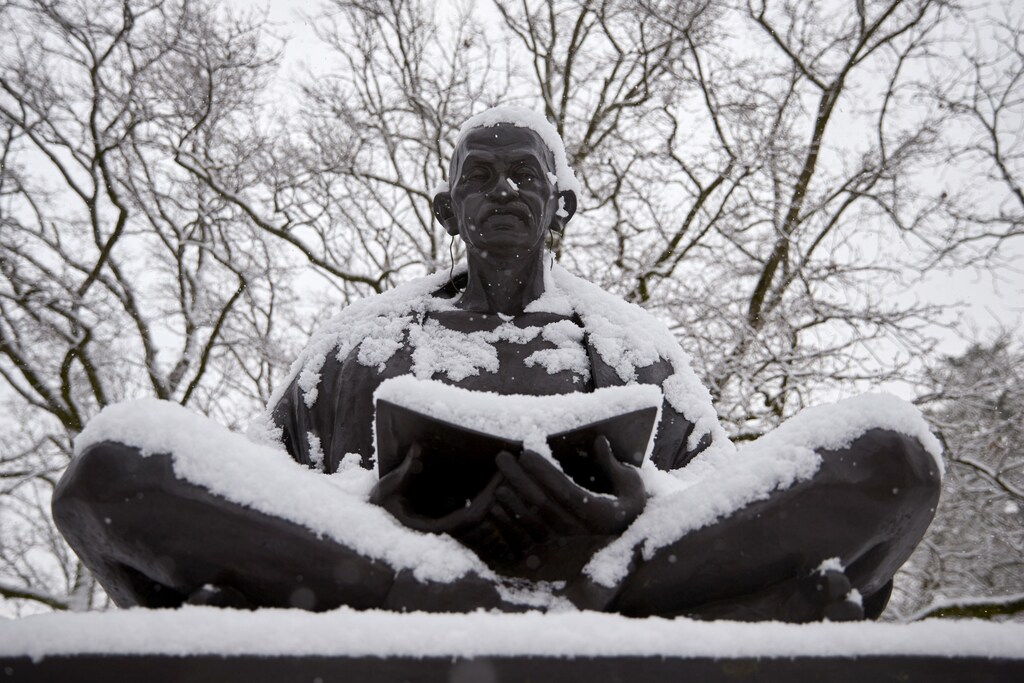 Snow falls on a statue of Mahatma Gandhi on a winter morning in the Ariana Parc outside the European headquarters of the United Nations in Geneva February 2, 2015.