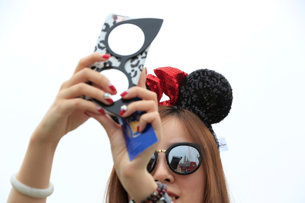 A girl takes pictures after opening ceremony at Shanghai Disney Resort in Shanghai, China, June 16, 2016. REUTERS/Aly Song - S1AETKENMJAB