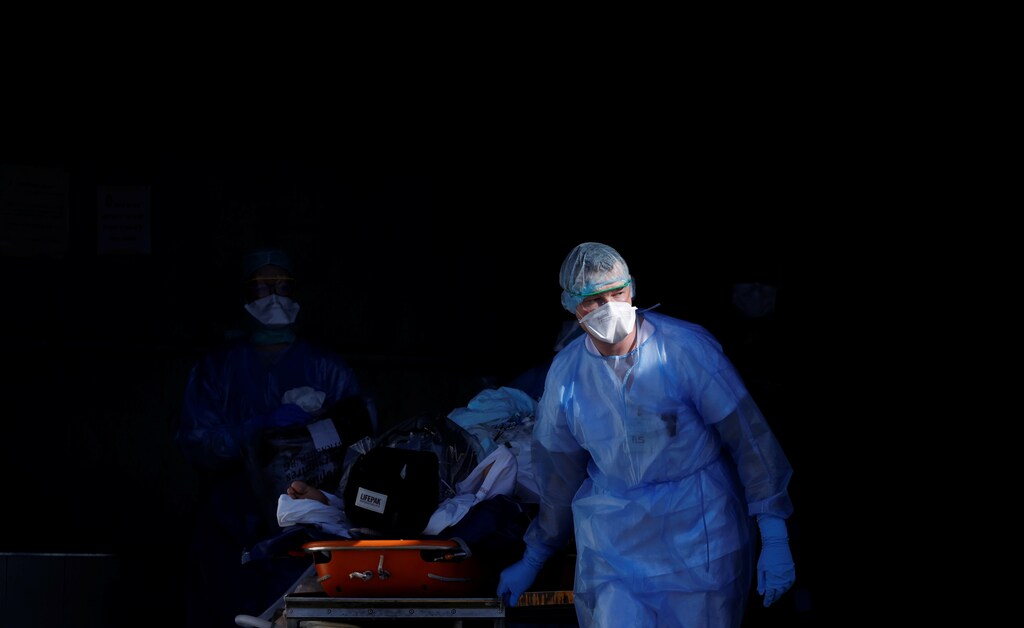 A patient infected with coronavirus is carried on a stretcher by a French rescue team before being transferred by a helicopter of the civil security (Securite Civile) from Strasbourg university hospital to Pforzheim in Germany as the spread of the coronavirus disease (COVID-19) continues in France, March 24, 2020. Picture taken March 24, 2020. REUTERS/Christian Hartmann - RC2P1G9PG3SI