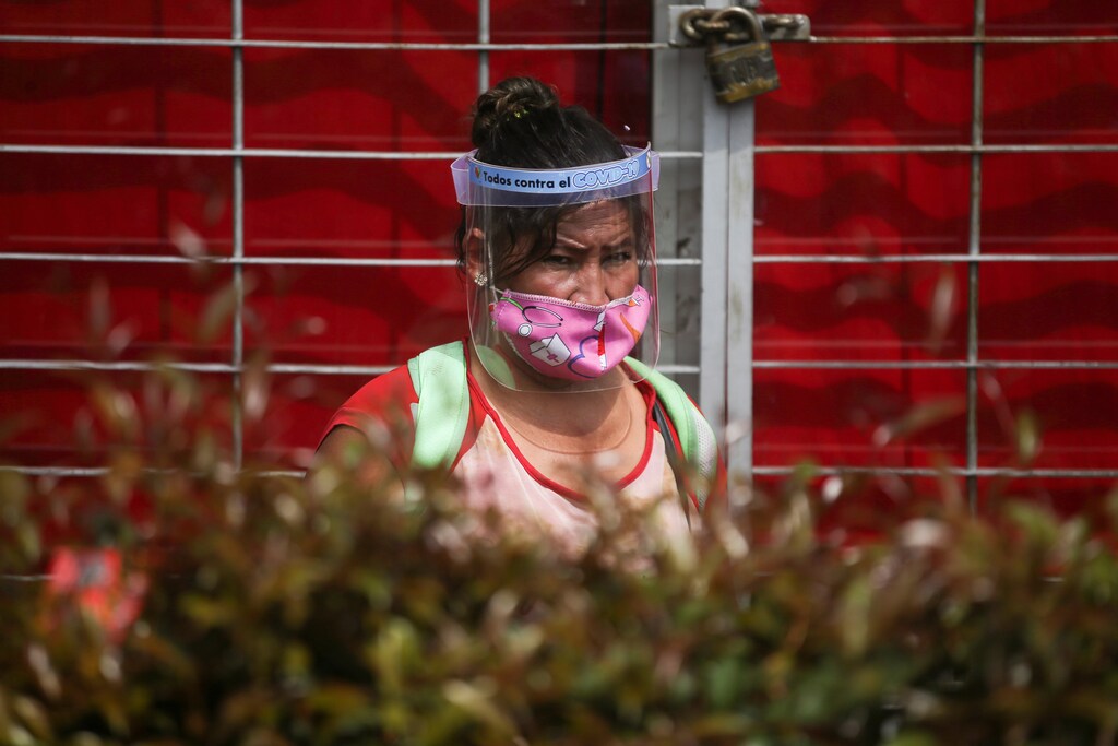 Una mujer con máscara y protector facial es vista fuera de un supermercado, después de que el gobierno permitiera a ciertos sectores volver al trabajo, en medio del brote de la enfermedad coronavirus (COVID-19) en Bogotá, Colombia, el 11 de mayo de 2020.
