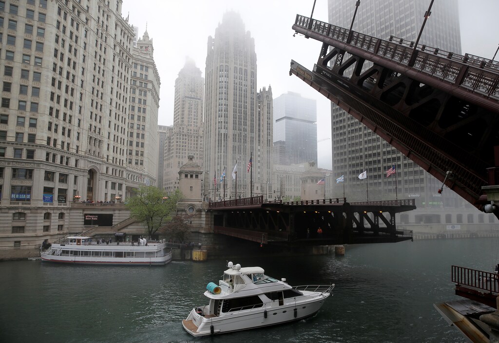 A boat passes under a raised bridge across from the Chicago Tribune building (C) in Chicago, Illinois, United States, May 11, 2016. REUTERS/Jim Young - RTX2DWSD