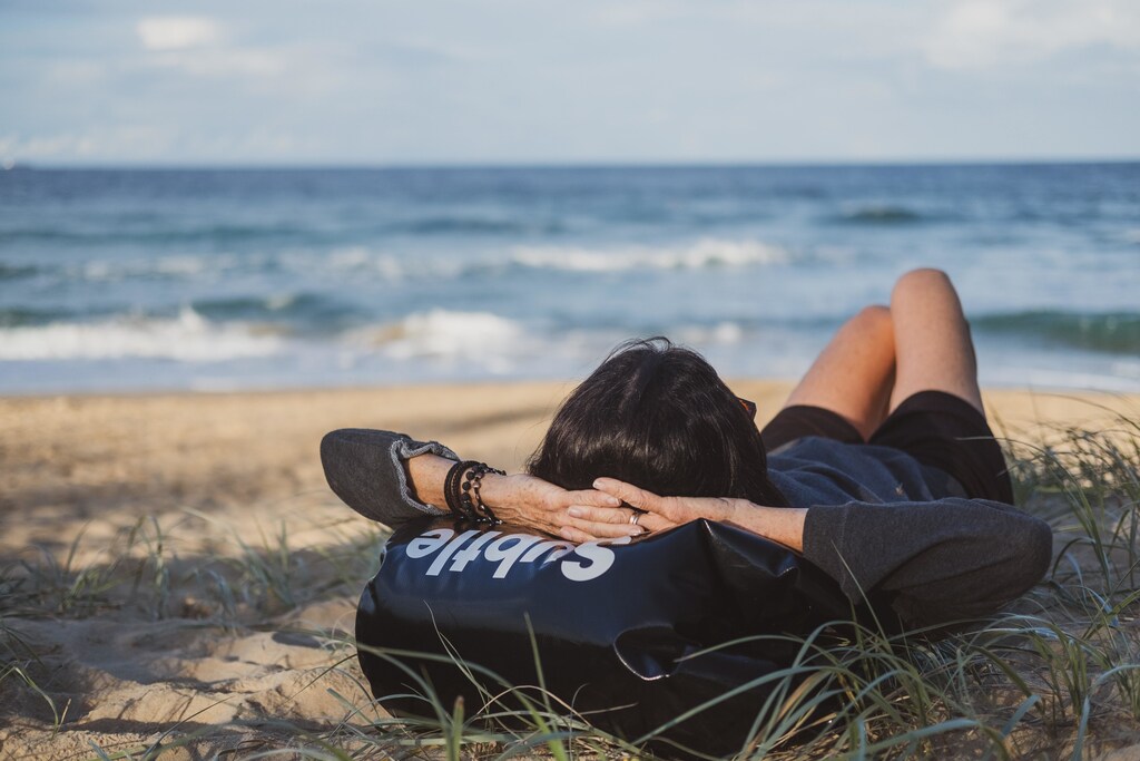 A person napping on the beach.