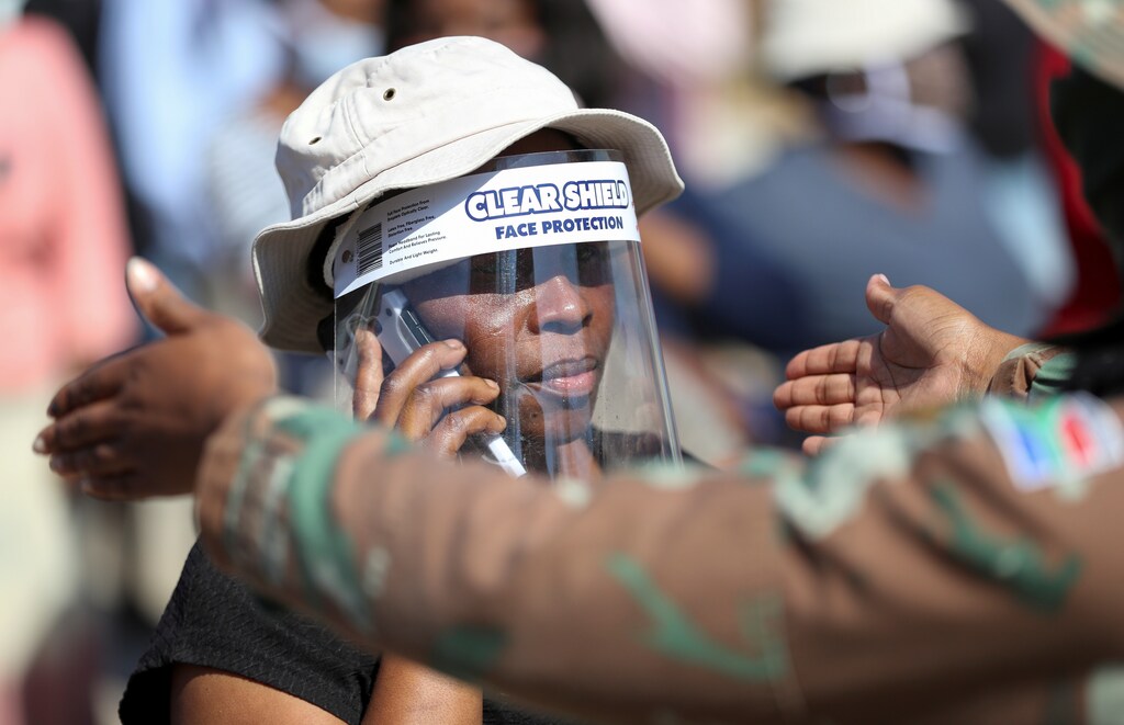 Una mujer usa un protector facial durante la distribución de alimentos, mientras Sudáfrica comienza a relajar algunos aspectos de un riguroso cierre de la enfermedad coronavirus nacional (COVID-19), en Diepsloot cerca de Johannesburgo, Sudáfrica, el 8 de mayo de 2020.